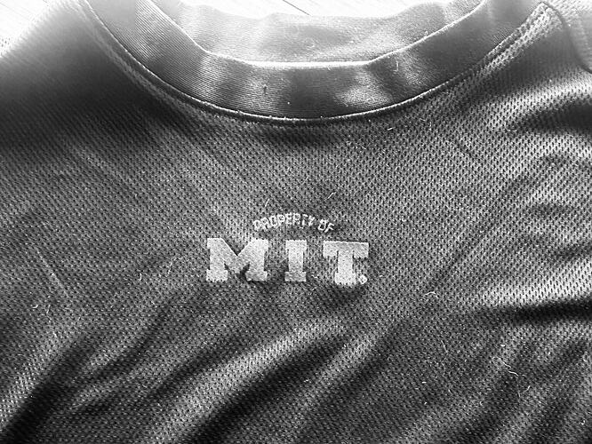 black and white image of the top of a shirt that reads Property of MIT