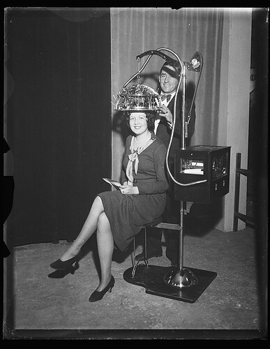 Woman seated with a psychograph, a phrenology machine, on her head