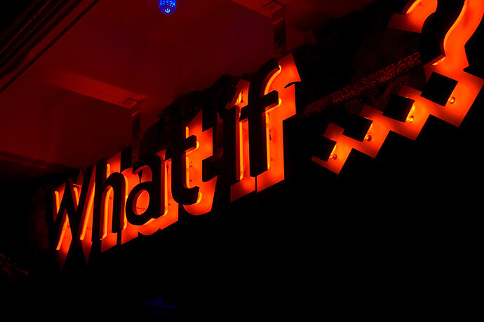 What if? sign lit up at night.