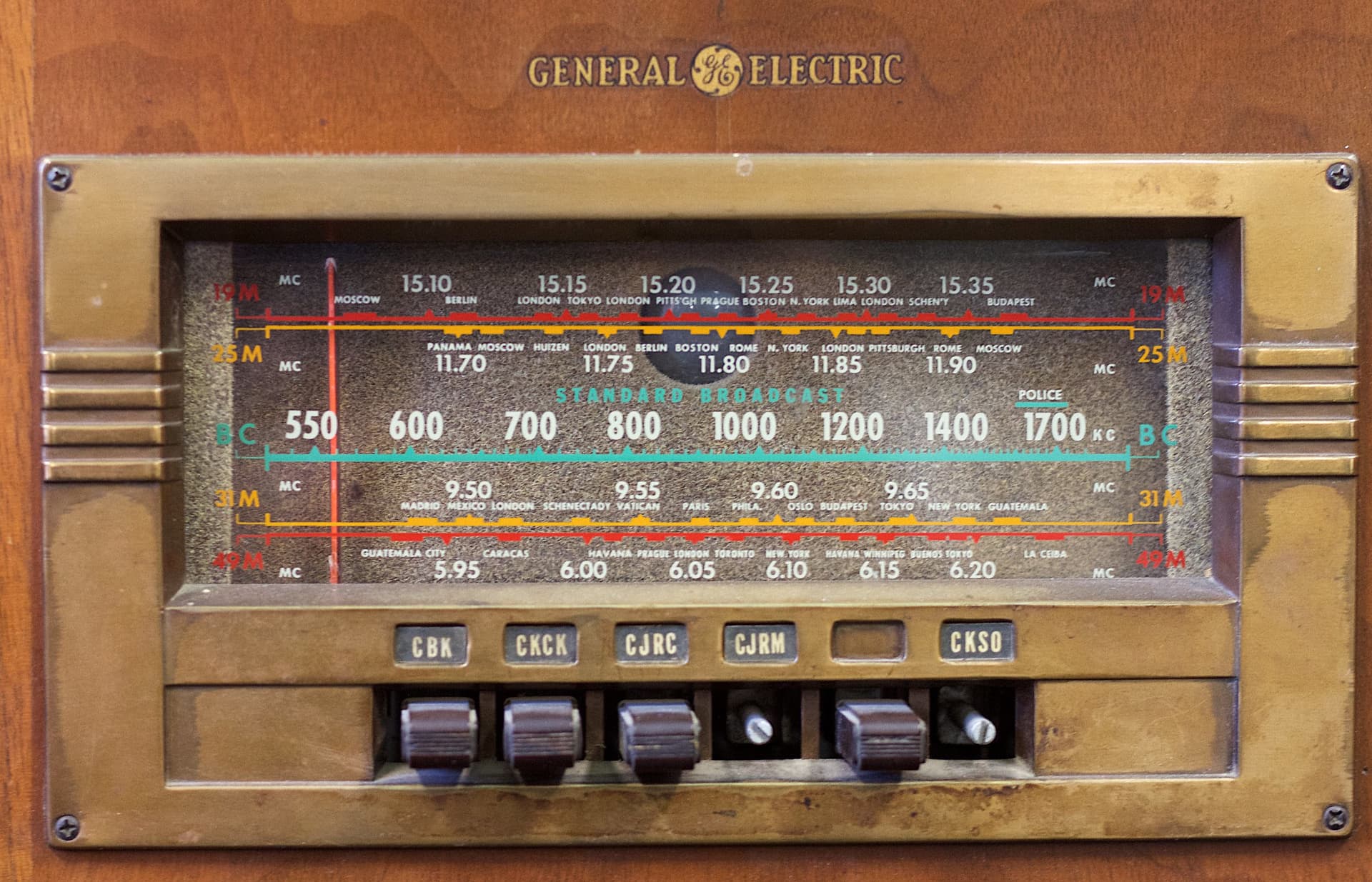 Antique General Electric brand radio with multiple bands and 6 buttons below, 2 of which are missing