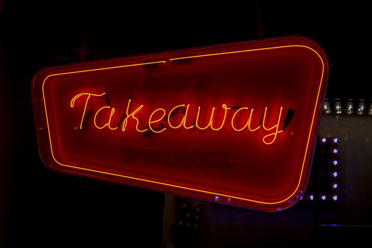 Neon sign at night with the word Takeway written in script style